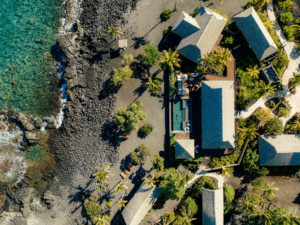 Aerial view of Kona Village Resort Kailua-Kona Hawaii showing rebuilt oceanfront bungalows with Endureed engineered thatch roofing along Hawaii's lava coastline