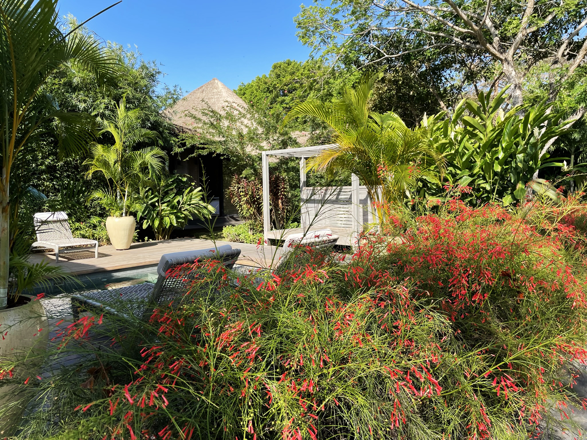 Outdoor living deck at Casa Loro Panama with Endureed bespoke synthetic thatch roof overhang, custom engineered thatch on private resort-style tropical estate pavilions Pedasi Panama