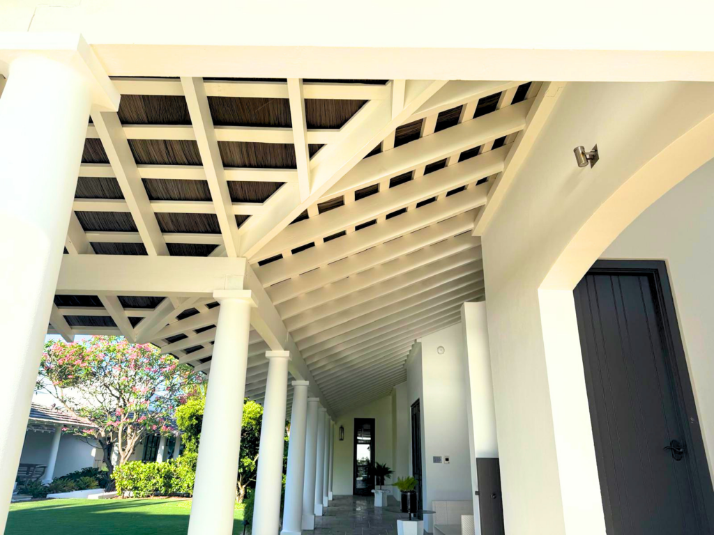 Endureed Kilimanjaro engineered thatch roof on white stucco luxury residence surrounded by palm trees and tropical landscaping, Bahamas