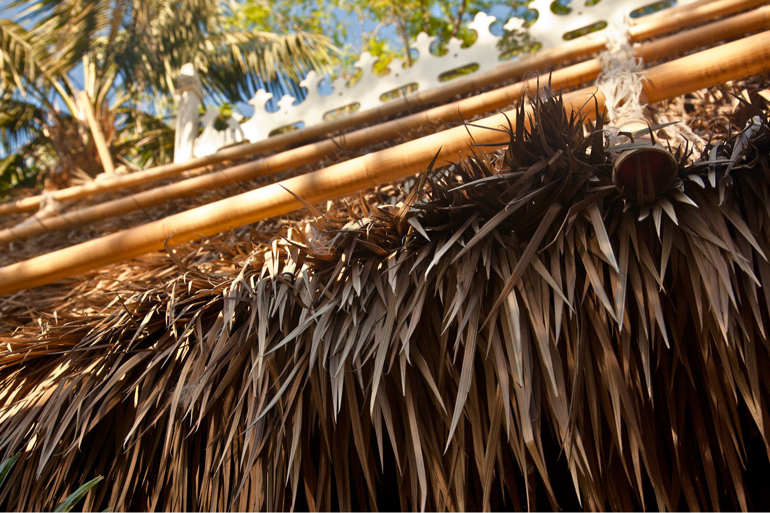 Close-up texture detail of Endureed Premium Dominica engineered thatch layers and bamboo framework at Disneyland Adventureland &mdash; frond layering, ridge construction, and depth visible