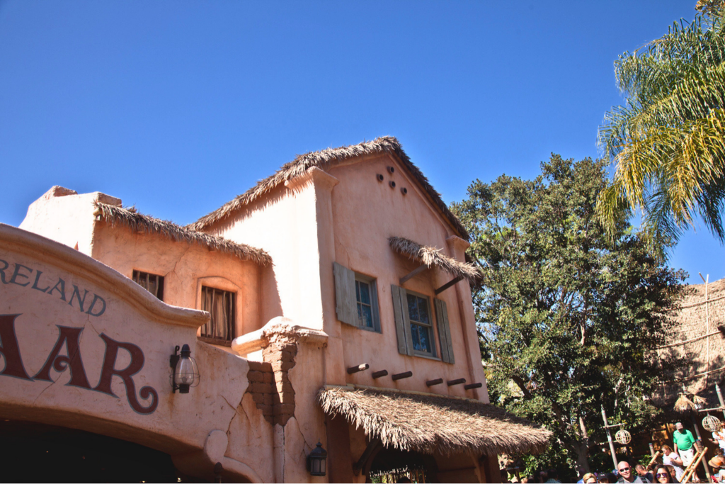 Endureed Premium Dominica synthetic thatch eave and canopy accents on Adventureland Bazaar building at Disneyland Anaheim &mdash; thatch applied to adobe-style commercial architecture