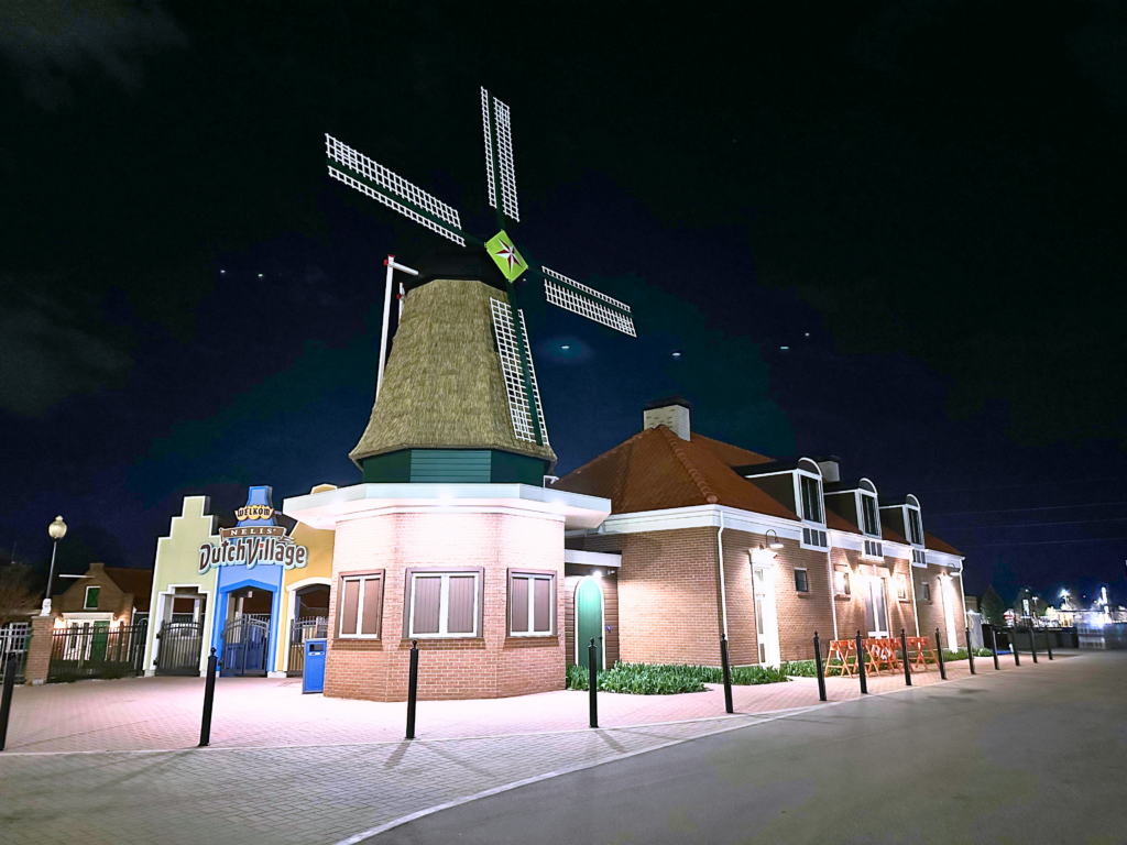 Endureed Somerset engineered thatch on Nelis Dutch Village windmill Holland Michigan at night, premium synthetic thatch cladding illuminated on theme park landmark structure for year-round entertainment venue