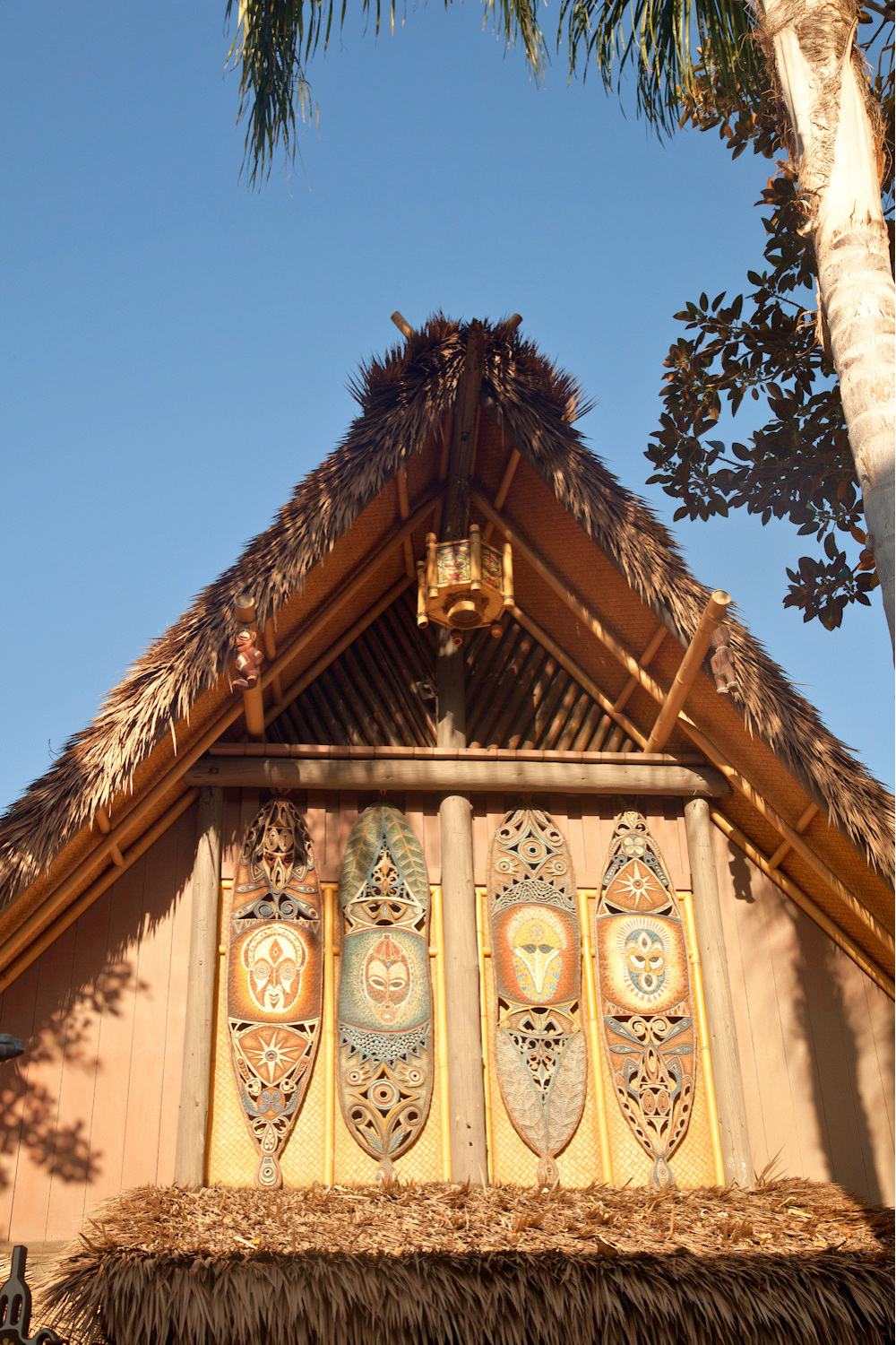 Adventureland building facade at Disneyland Anaheim featuring Endureed Premium Dominica engineered thatch roofline with tribal shield artwork and bamboo structural framing
