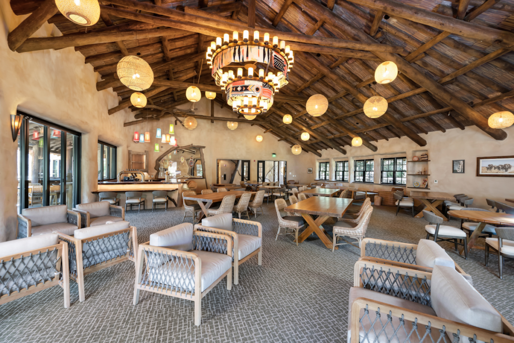 Interior of Elephant Valley dining hall at San Diego Safari Park showing exposed wood beam ceiling structure beneath Endureed engineered thatch roof, commercial synthetic thatch for indoor-outdoor zoo restaurant