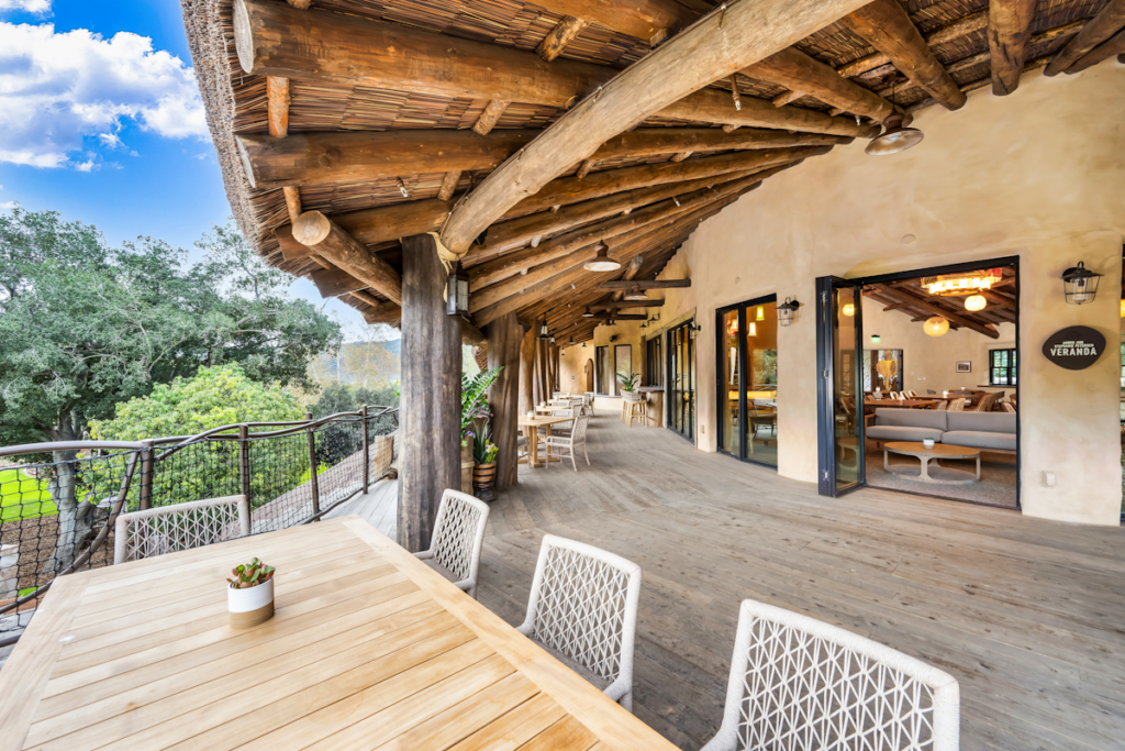 Covered veranda at Elephant Valley San Diego Safari Park with Endureed synthetic thatch overhang above upper-level outdoor deck, engineered thatch roofing for elevated hospitality structures at zoo venues