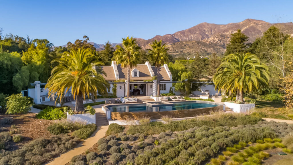 Aerial drone view of Dean's Grange private estate in Malibu California featuring Endureed Premium Kilimanjaro synthetic thatch roofing &mdash; luxury Cape Dutch residence with engineered thatch roof, infinity pool, and Santa Monica Mountains panorama